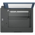 Open printer with the top lid raised, exposing the internal paper feed path and input area on the left.
